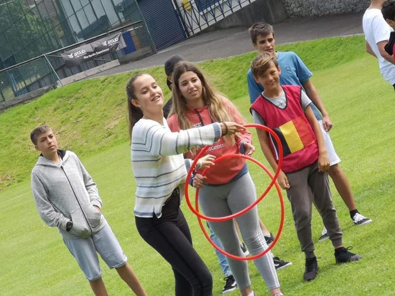 Een meisje gooit een hoola hoop met andere jongeren tijdens een taalreis engels