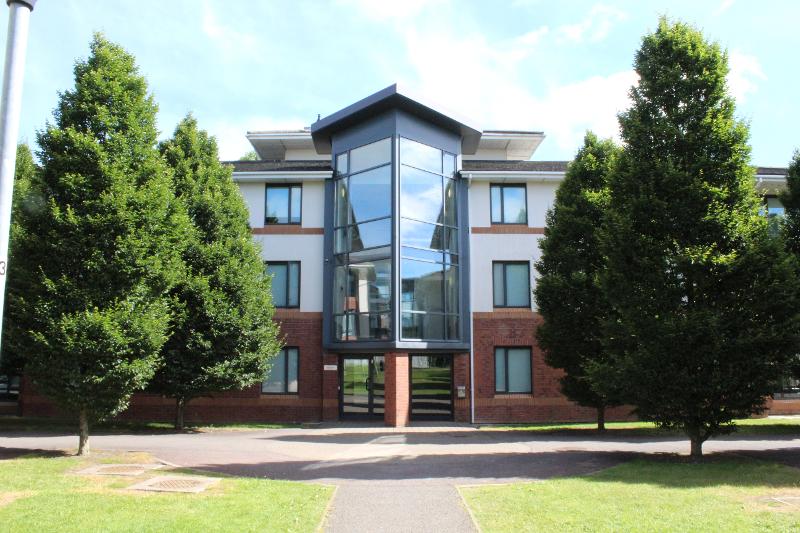 De voorkant van een gebouw met bomen tijdens een taalreis engels