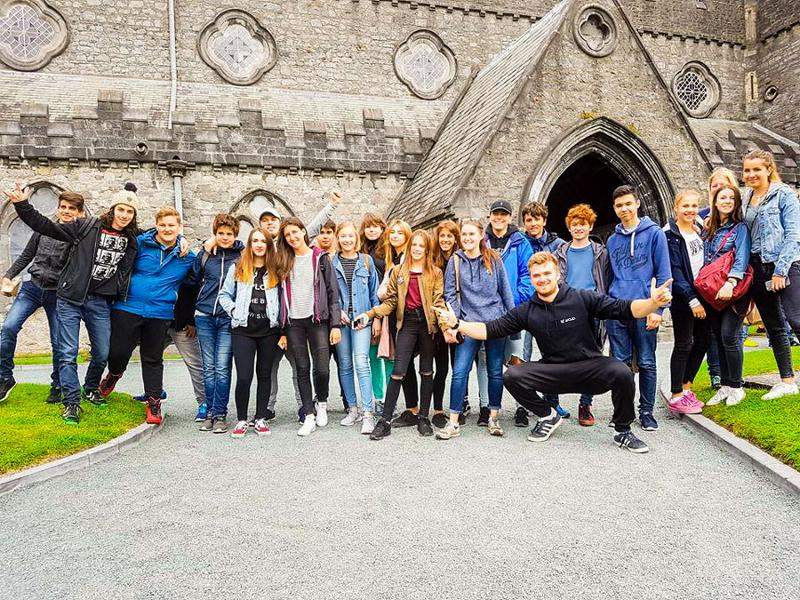 Een groepsfoto van jongeren voor een kerk tijdens een taalreis engels