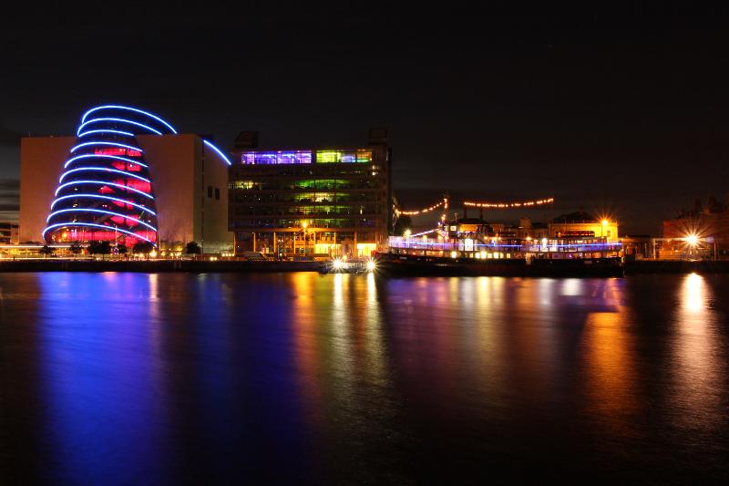 Gebouwen en een schip gezien van een rivier 's avonds tijdens een taalreis engels
