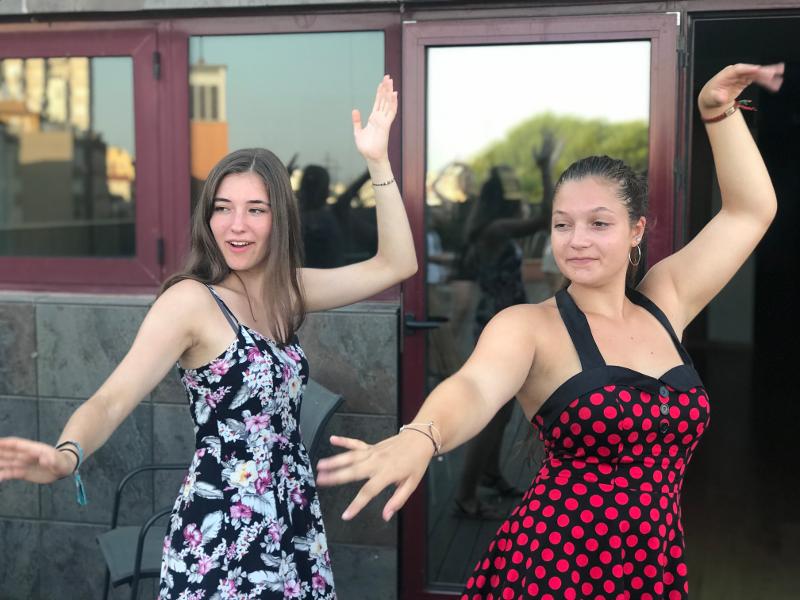 Twee meisjes krijgen dansles tijdens een taalreis spaans