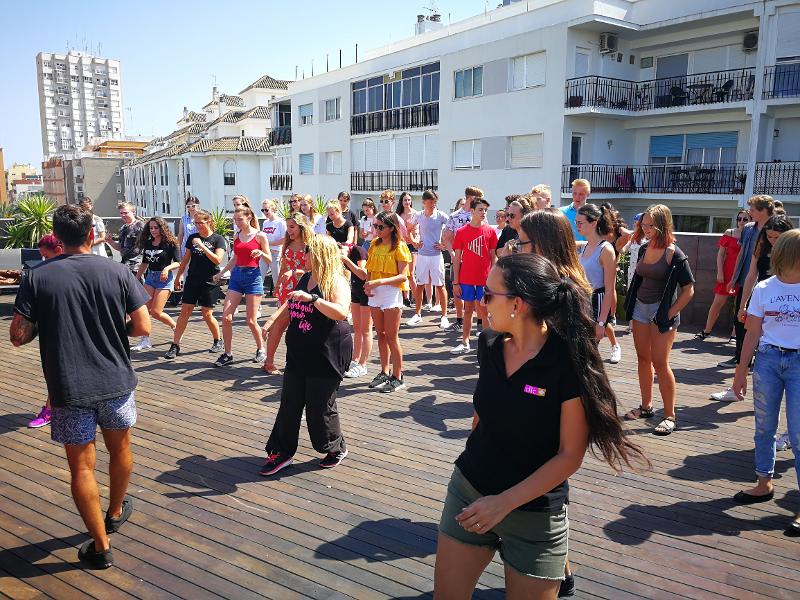Jongeren krijgen dansles op het dakterras tijdens een taalreis spaans