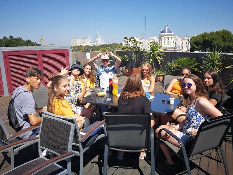 Jongeren zitten op een dakterras tijdens een taalreis spaans