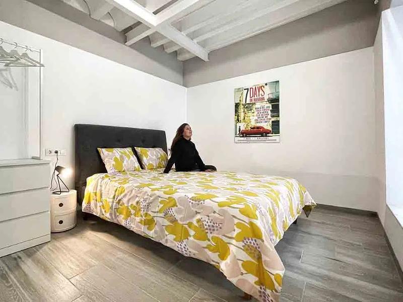 Een meisje zit op een bed in een slaapkamer tijdens een taalreis spaans