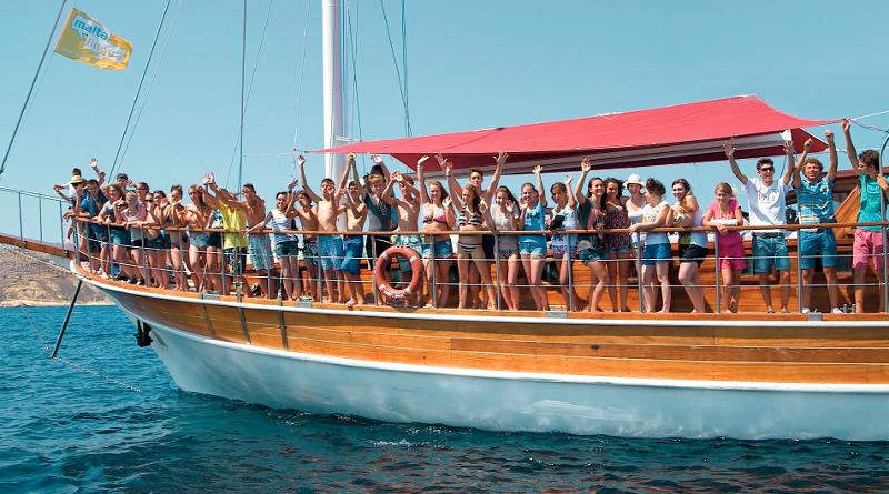 Alle deelnemers varen op een boot en zwaaien tijdens taalreis Malta