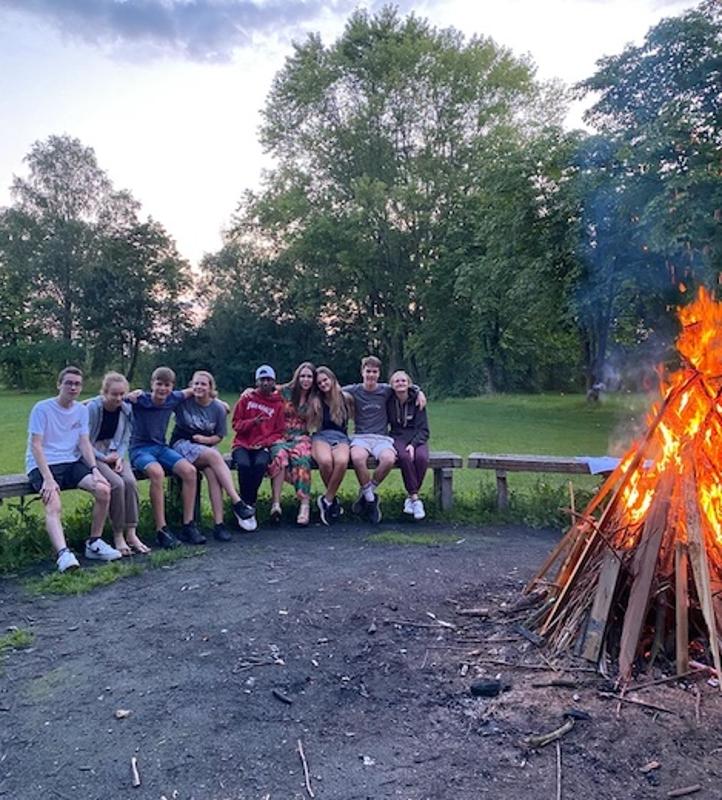 deelnemers van het taalkamp Engels in Nederland zitten rondom het kampvuur
