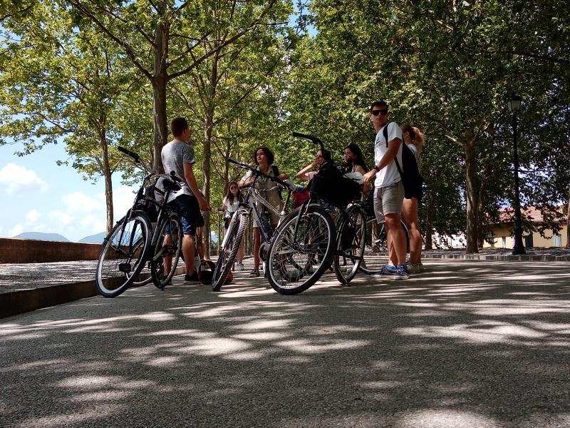 Groep deelnemers wachten naast de fiets tijdens de taalreizen Italië