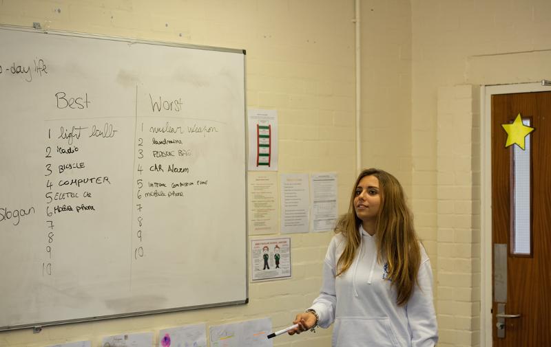 Een meisje staat bij een whiteboard in een lokaal tijdens een taalreis engels