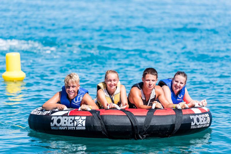 Vier jongeren liggen op een opblaasbare boot tijdens een taalreis frans
