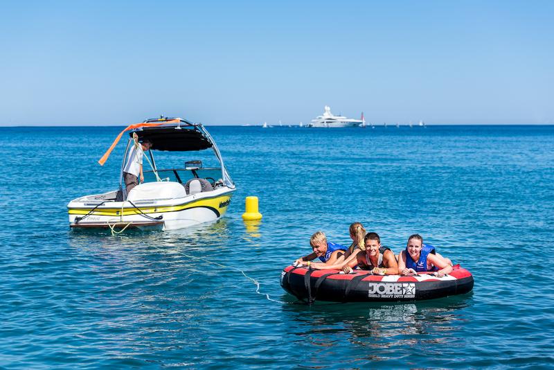 Vier jongeren op een opblaasbare boot achter een speedboot tijdens een taalreis frans