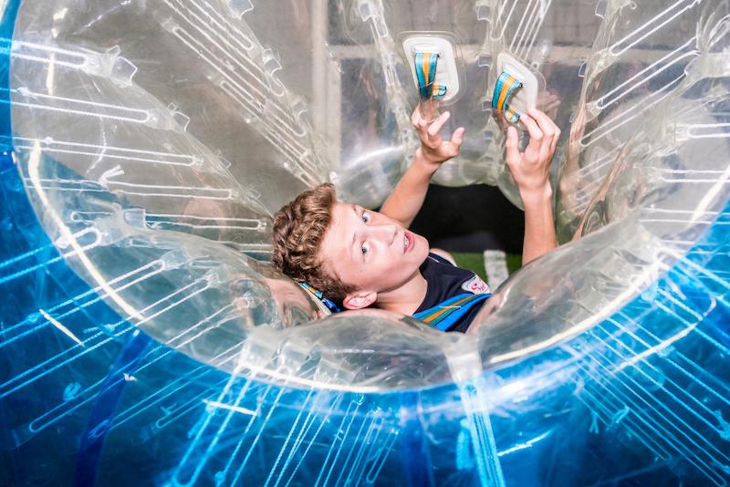 Een jongen zit in een opblaasbare bal tijdens een taalreis frans