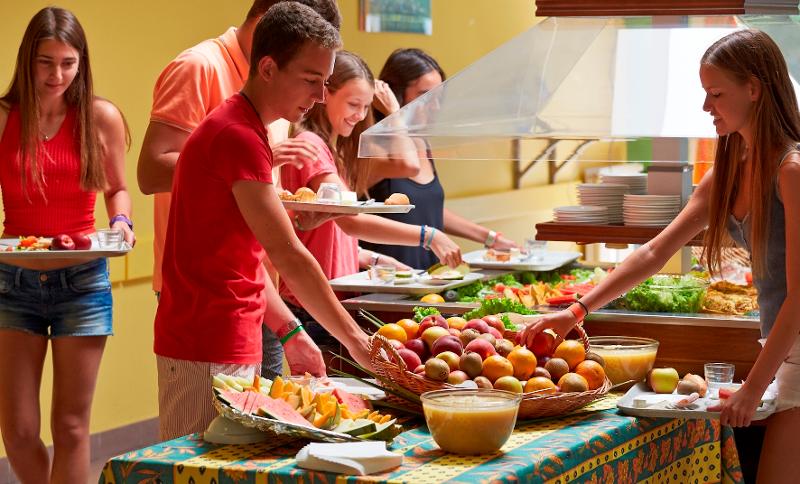 Jongeren pakken eten van het buffet tijdens een taalreis frans