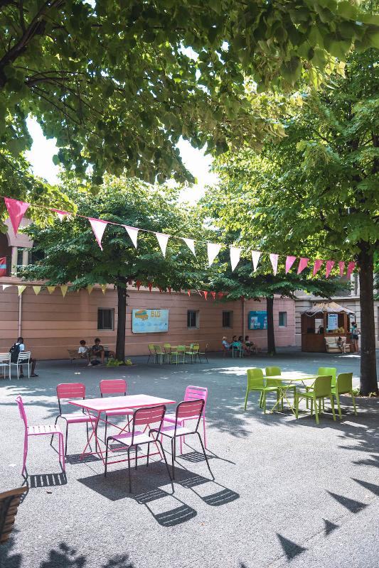 Een plein met bomen, tafels en stoelen tijdens een taalreis frans