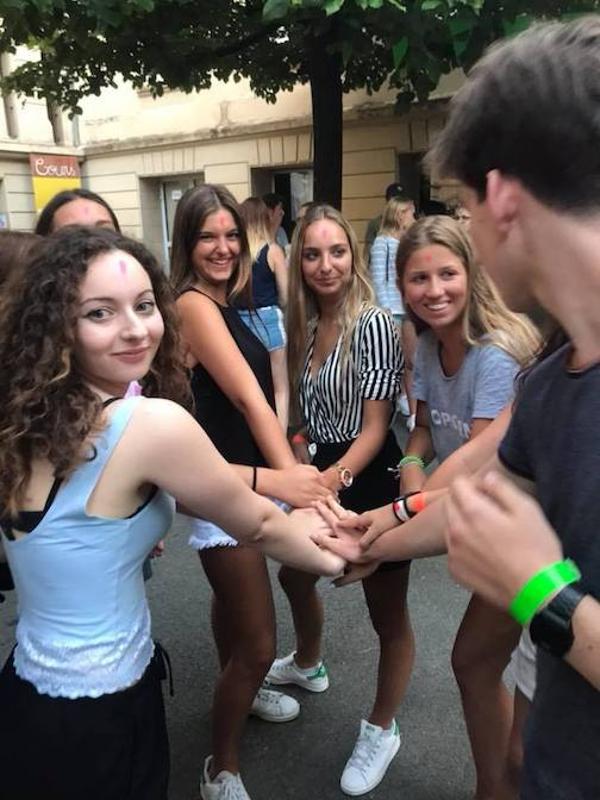 Een groep jongeren houdt de handen bij elkaar op een plein tijdens een taalreis frans