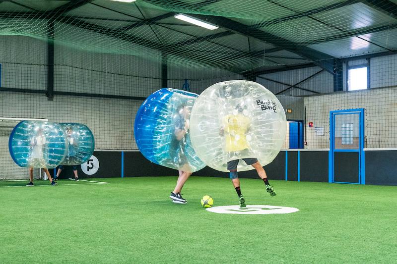 Jongeren spelen voetbal in opblaasbare ballen tijdens een taalreis frans