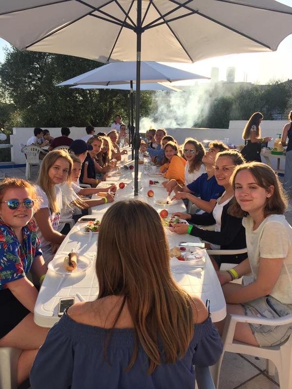 Jongeren zitten buiten aan tafel tijdens een taalreis frans