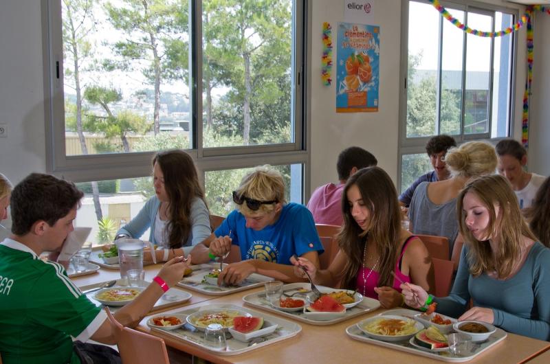 Jongeren eten lunch in een kantine tijdens een taalreis frans