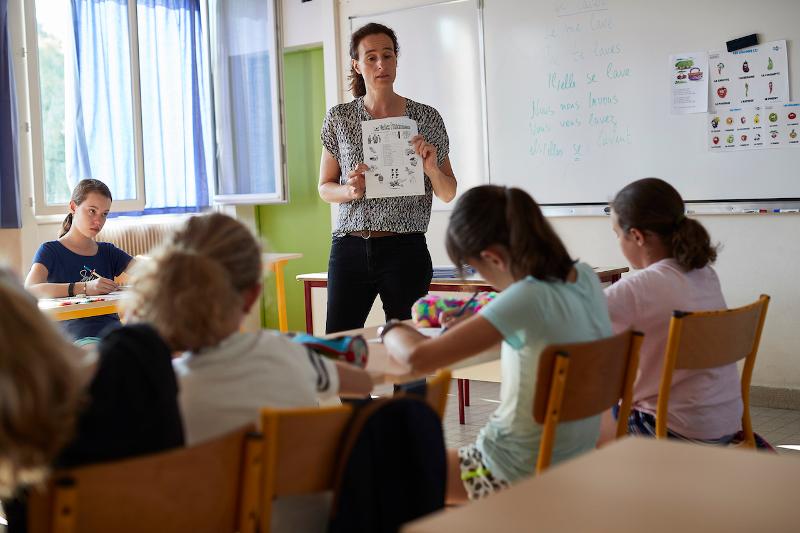 Een docent geeft uitleg aan kinderen tijdens een taalreis frans