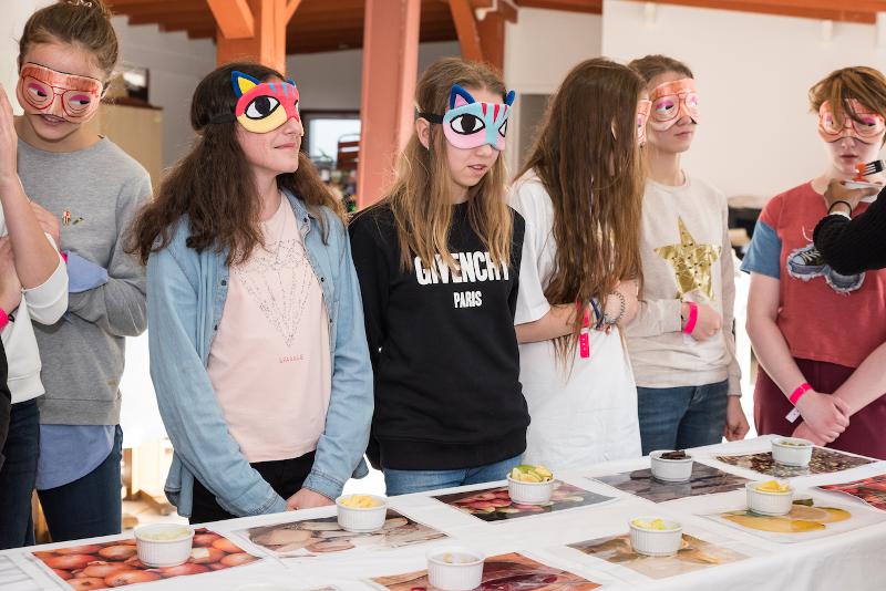 Jongeren met een blinddoek voor en een tafel met eten tijdens een taalreis frans