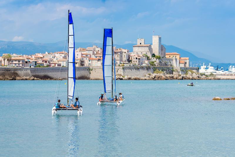 Twee catamarans voor de kust bij een stad tijdens een taalreis frans