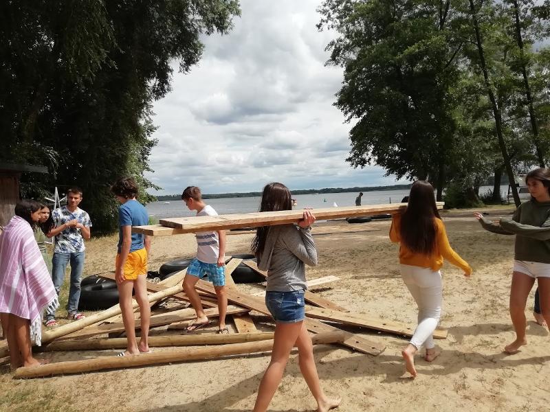 tieners aan het bouwen aan een raft tijdens natuurkamp