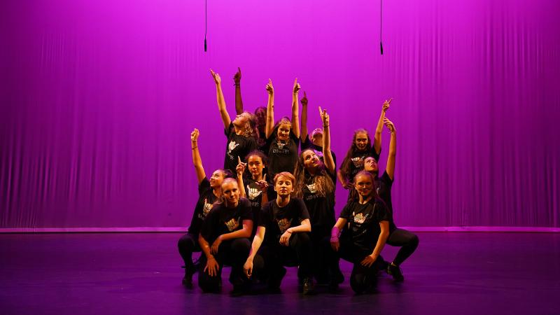 Poseren op het podium in roze licht tijdens het musicalkamp