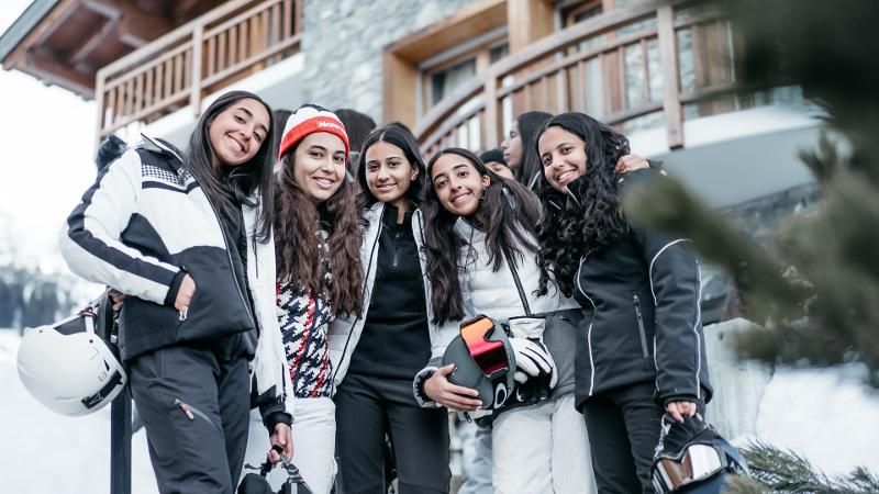 Deelnemers van jongeren groepsreis wintersport samen op de foto voor accommodatie