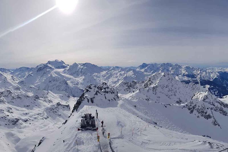Bergtoppen op de foto met zon op de achtergrond tijdens jongeren groepsreis wintersport