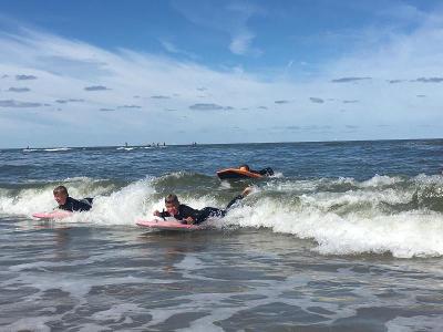 jongens bodyboarden in de zee op surfkamp zandvoort zomer