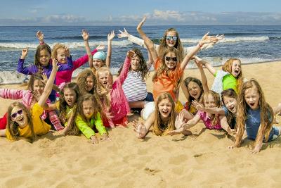 Kinderen poseren in het strand op jeugdkamp.