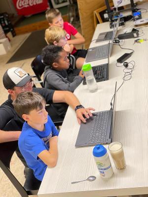 jongens krijgen uitleg over gamen op de laptop op gamekamp schoten