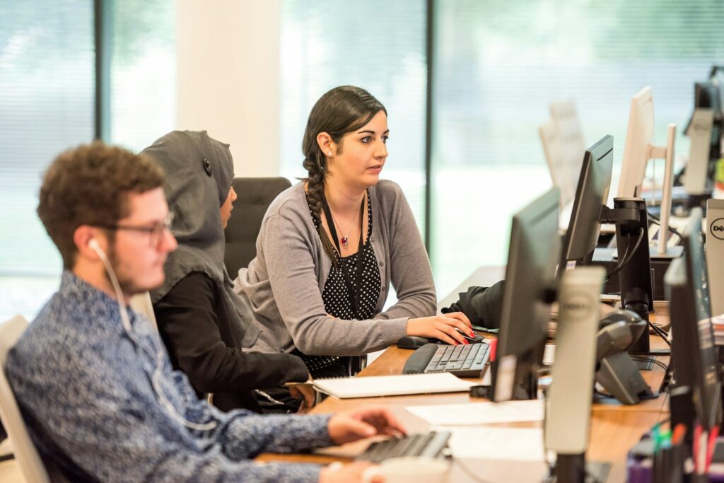 Collega's zijn aan het werk achter de computer op een Engelse stage