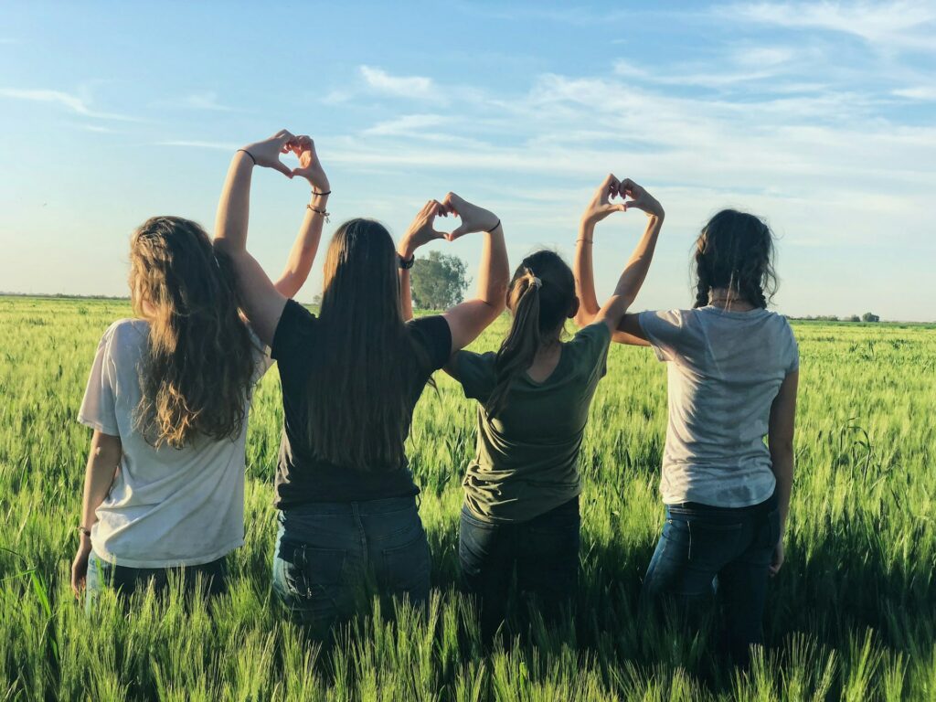 vriendinnen in een veld van jonge leeftijd die elkaar hebben ontmoet tijdens het kamp in het buitenland 