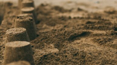 Zandkasteel op het strand tijdens de schoolvakantie in regio Zuid.