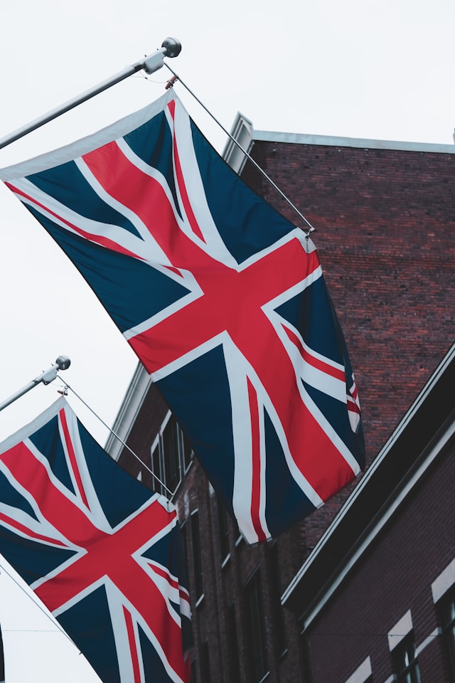 Enegels leren met een uitzicht op twee vlaggen van het verenigd koningkrijk wapperend aan het zijkant van een gebouw