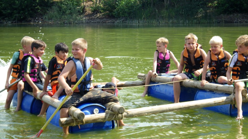 Kinderen op vlot op kamp tijdens de schoolvakantie.