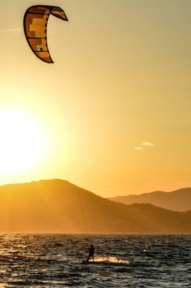 verschillende soorten surfen, een surfer in de zonsopkomst, kitesurfen