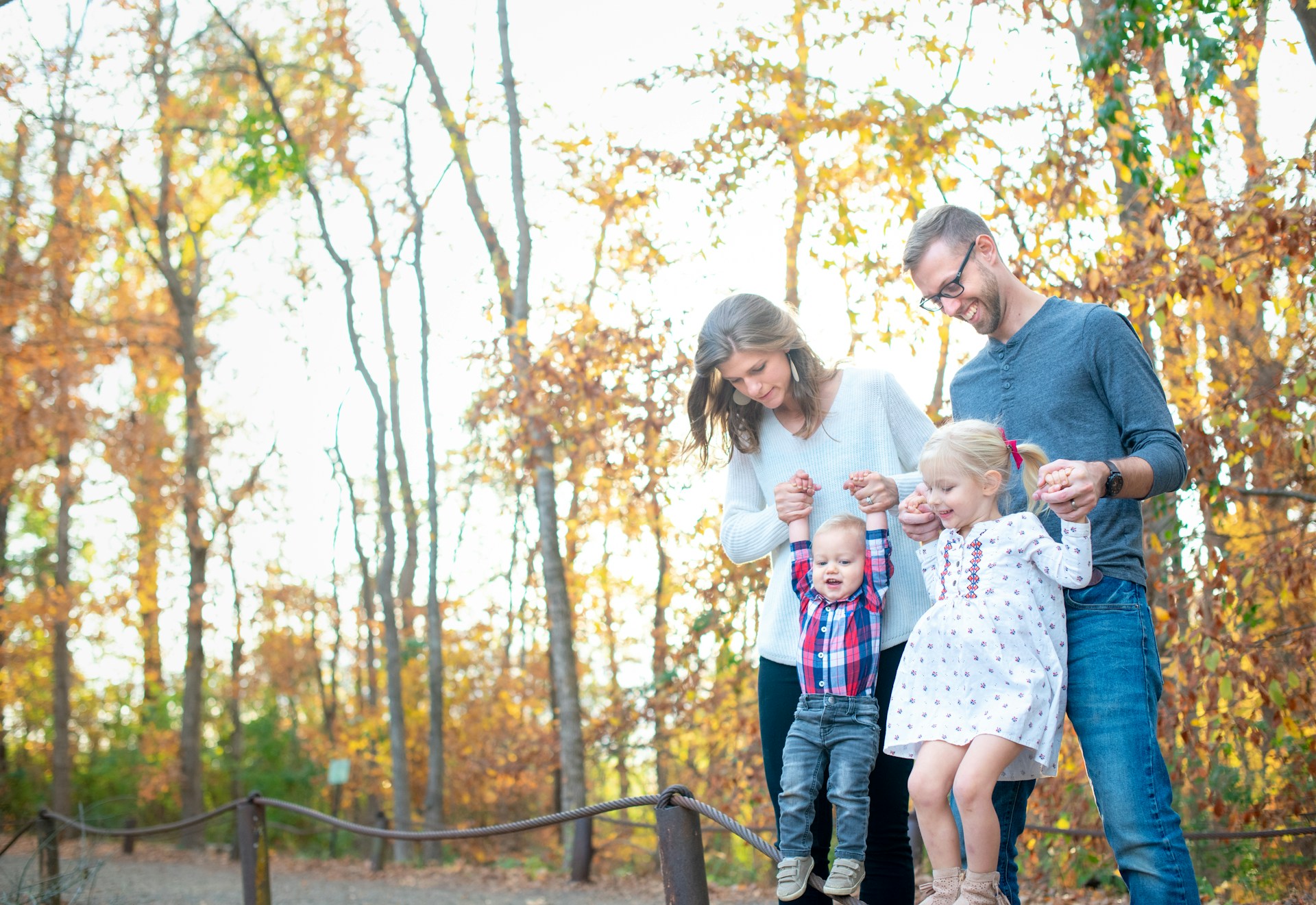 Ouders zijn met hun kinderen in het bos een activiteit aan het doen tijdens de herfstvakantie