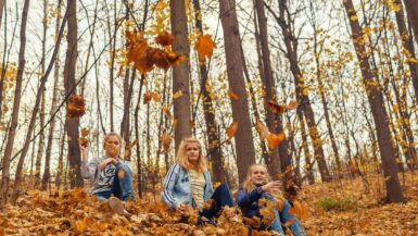 Familie doet activiteit in het bos - herfstvakantie in Vlaanderen